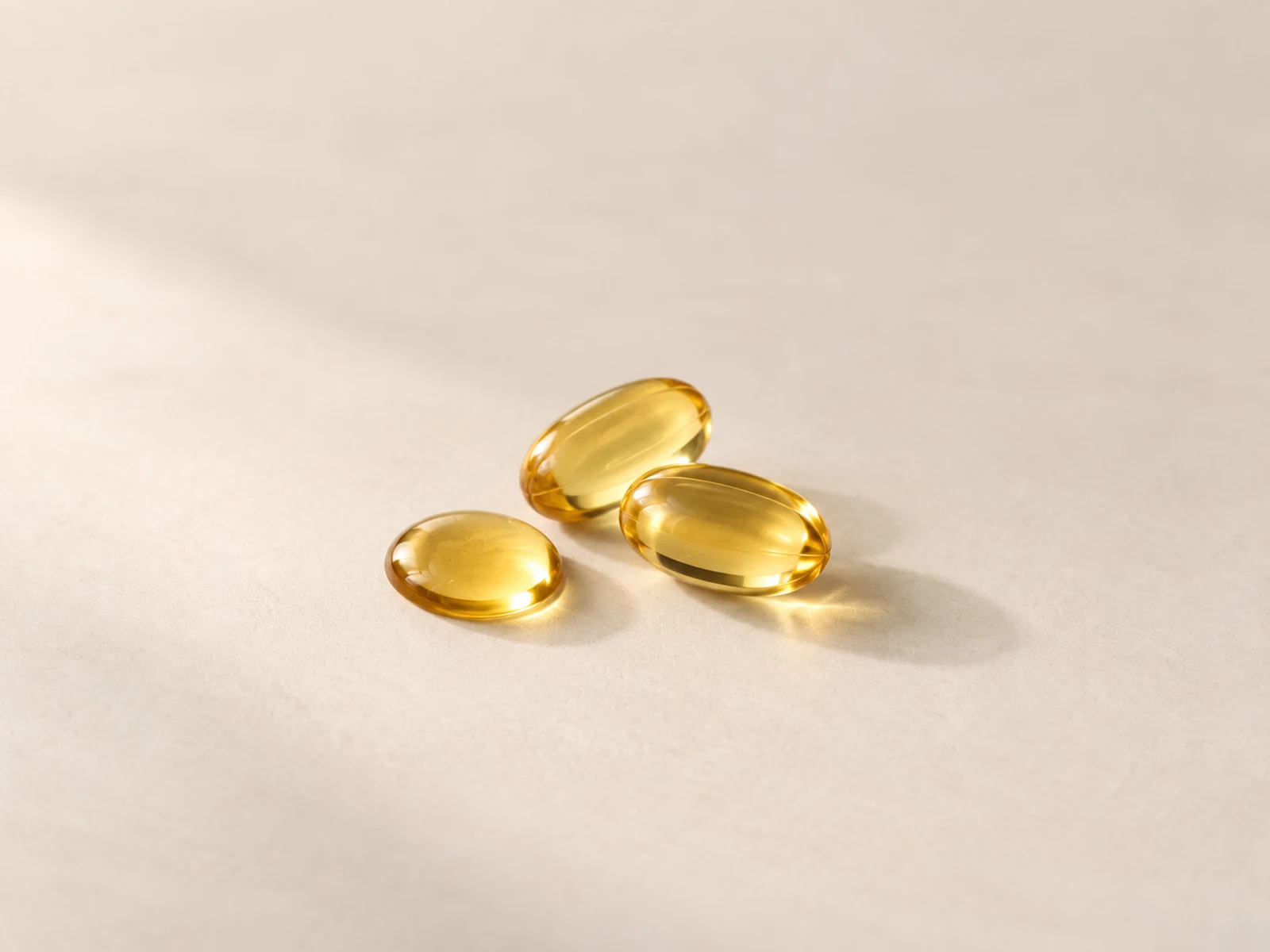 Folinove Cápsulas de aceite dorado sobre fondo crema